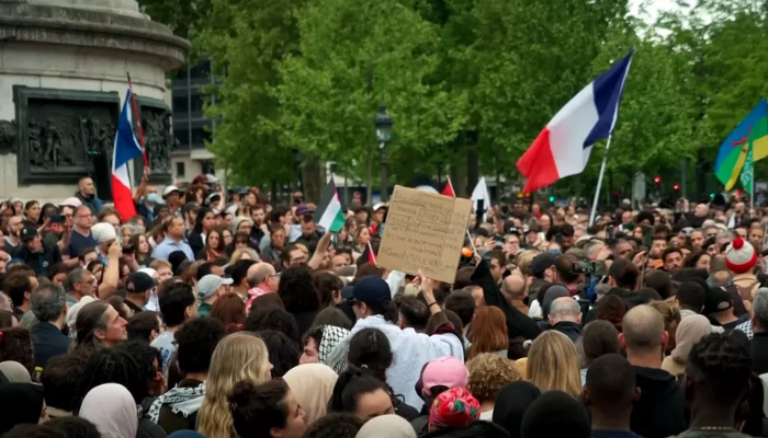 Protesters holding signs at an anti-Islamophobia demonstration in Paris after the fatal mosque attack in La Grand Combe.
