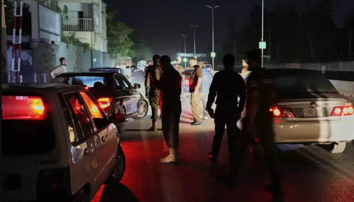 Pakistani police officers clearing the entrance of Nur Khan airbase after reported Indian missile strike.