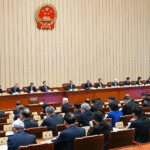 Chinese flag waving in front of Great Hall of the People during NPC meeting on Foreign Trade Law revision 2025
