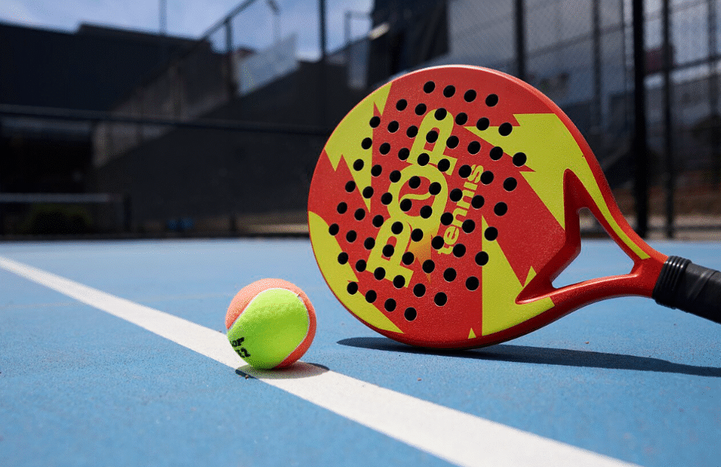 Players enjoy a lively padel doubles match on a glass-walled court, showcasing the fast-paced and social nature of the world’s fastest-growing racquet sport in 2026.

Alt text: