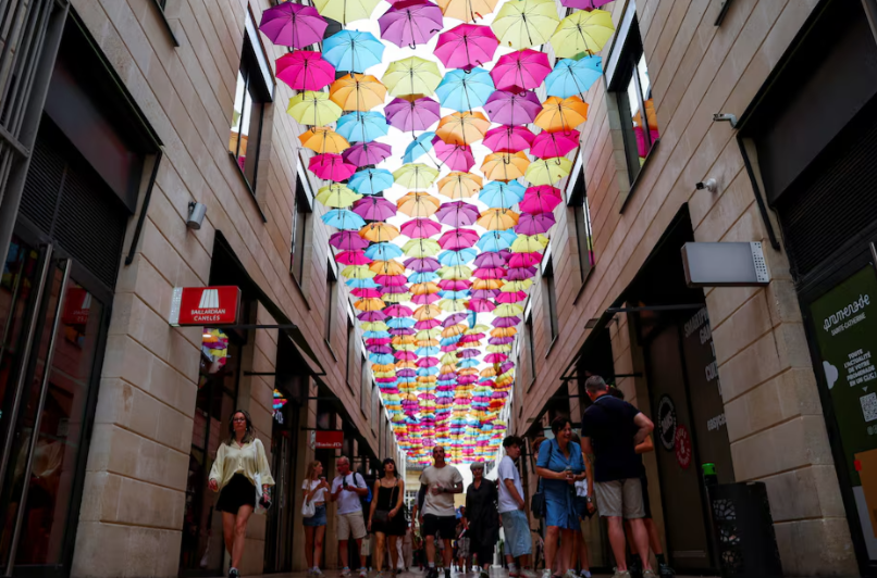Consumers walk past retail stores in Europe as Eurozone confidence improves to its highest level since February 2025, signaling cautious optimism despite ongoing economic uncertainties.